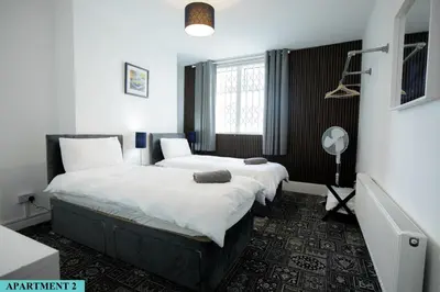 two beds in a room with white walls at St Luke's 2 in Liverpool