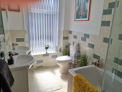 a bathroom with a tub and a toilet and a sink at Tiffy's Place in Blackpool