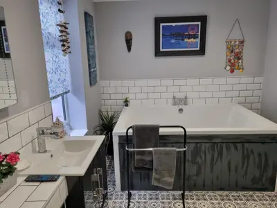 a bathroom with a tub and a sink at Tiffy's Place in Blackpool