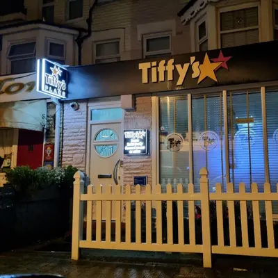 a white picket fence in front of a fast food restaurant at Tiffy's Place in Blackpool