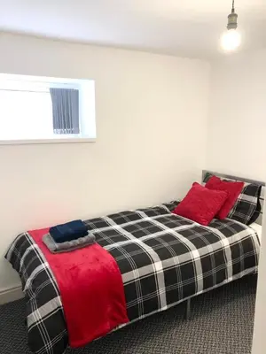 a bedroom with a bed with red pillows on it at CLIFTON Apartments in Liverpool