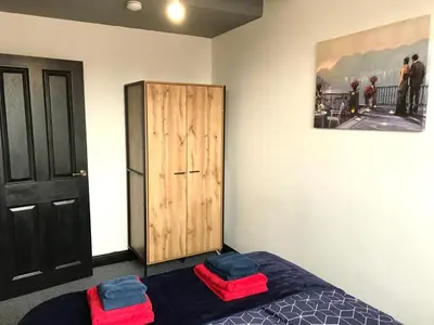 a bedroom with a bed and a wooden cabinet at CLIFTON Apartments in Liverpool