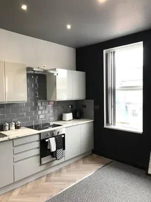 a kitchen with white cabinets and a window at CLIFTON Apartments in Liverpool
