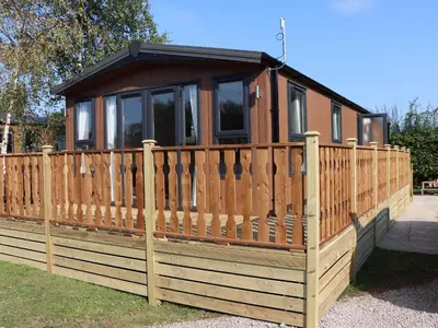 a small house with a wooden fence at Hawthorn Lodge in Carnforth
