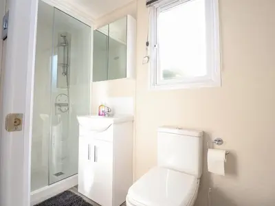 a bathroom with a toilet and a sink and a shower at Hawthorn Lodge in Carnforth