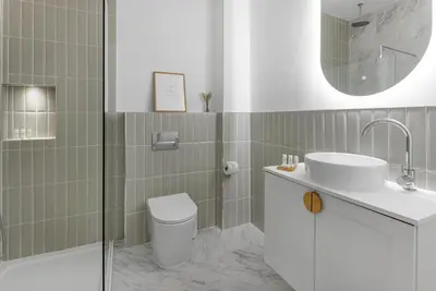 a bathroom with a sink and a toilet and a mirror at 44 Renshaw Apart Hotel in Liverpool