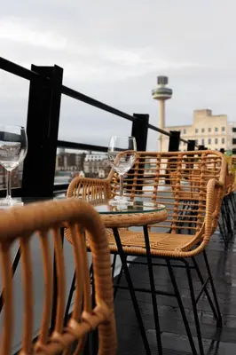 a table and chairs with wine glasses on a balcony at 44 Renshaw Apart Hotel in Liverpool