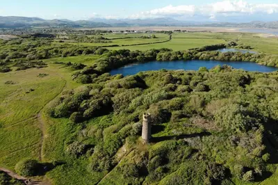 an old tower on a hill next to a river at Combe-n-Sea in Haverigg