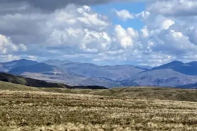 a view of a field with mountains in the background at Combe-n-Sea in Haverigg
