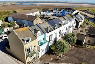 an aerial view of a row of houses with the ocean at Combe-n-Sea in Haverigg