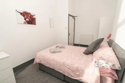 a bedroom with a bed with a pink blanket at Beautiful 2 Bedroom Apartment in Fleetwood in Fleetwood