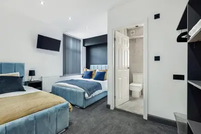 a hotel room with two beds and a toilet at Wellington Suites by Sasco Apartments in Blackpool