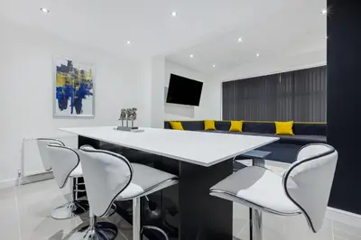 a dining room with a white table and chairs at Wellington Suites by Sasco Apartments in Blackpool