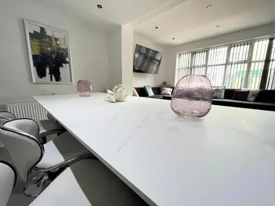 a white table with two pink chairs and a room at Wellington Suites by Sasco Apartments in Blackpool