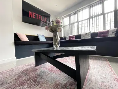 a living room with a couch and a vase with flowers at Wellington Suites by Sasco Apartments in Blackpool