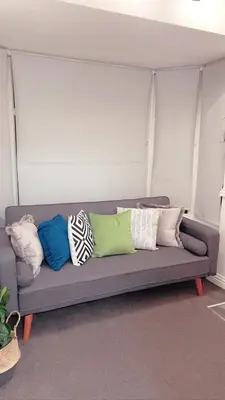 a gray couch with colorful pillows on it at Avril Apartments by CityNest1 in Blackpool