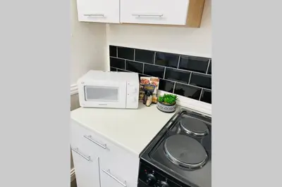 a kitchen with a stove and a microwave at Avril Apartments by CityNest1 in Blackpool