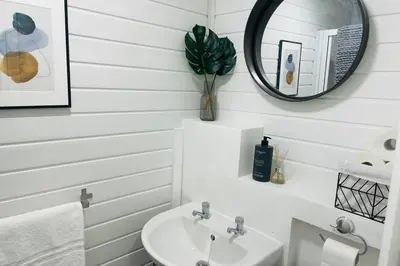 a white bathroom with a sink and a mirror at Avril Apartments by CityNest1 in Blackpool