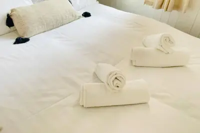 a white bed with towels on top of it at Avril Apartments by CityNest1 in Blackpool