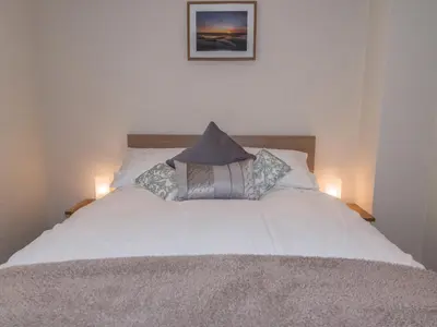 a bedroom with a white bed with two pillows at Seashells Cottage in Lytham St Annes