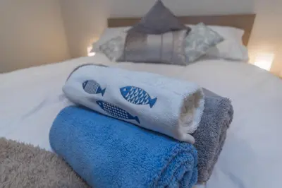 a bed with towels sitting on top of it at Seashells Cottage in Lytham St Annes
