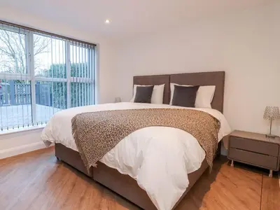 a bedroom with a large bed and a large window at ViewLangho in Blackburn