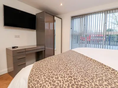 a bedroom with a bed and a desk and a television at ViewLangho in Blackburn