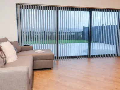 a living room with a couch and a large sliding glass door at ViewLangho in Blackburn