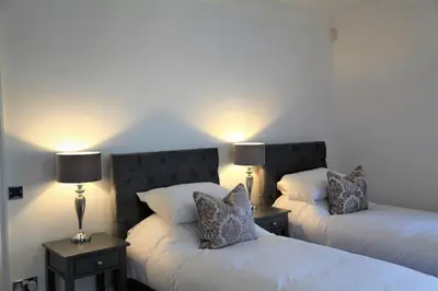 two beds in a room with two lamps on them at The Farmhouse at Ream Hills in Weeton