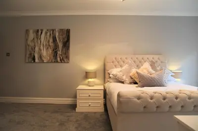 a bedroom with a bed with a nightstand and a painting at The Farmhouse at Ream Hills in Weeton