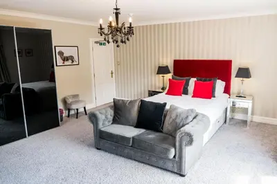 a bedroom with a bed and a couch and a chair at The Farmhouse at Ream Hills in Weeton