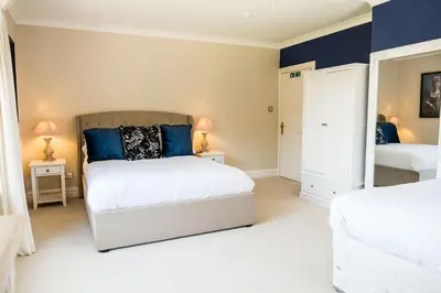 a bedroom with two beds and two lamps on tables at The Farmhouse at Ream Hills in Weeton