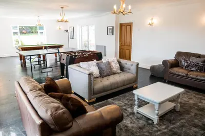 a living room with leather couches and a table at The Farmhouse at Ream Hills in Weeton