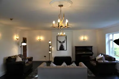 a living room with couches and a chandelier at The Farmhouse at Ream Hills in Weeton