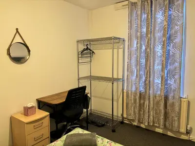 a room with a desk and a chair and a curtain at Entire 3 Bedroom House- FREE PARKING in Liverpool