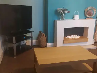 a living room with a tv and a fireplace at Lovely 2 bedroomed flat in the centre of Longton in Longton