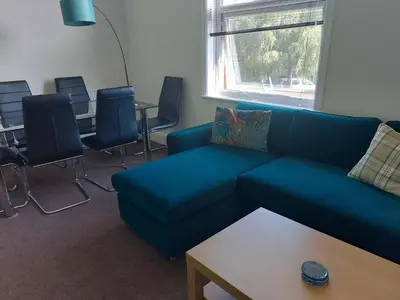 a living room with a couch and chairs and a table at Lovely 2 bedroomed flat in the centre of Longton in Longton