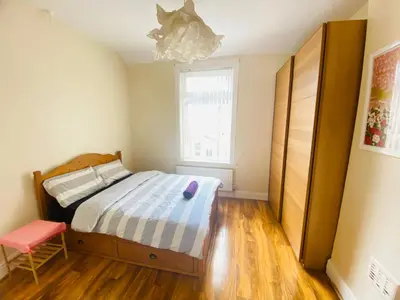 a small bedroom with a bed and a window at Entire 4 bedroom House - EV POINT & FREE PARKING in Liverpool