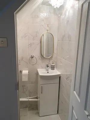 a white bathroom with a sink and a mirror at Entire 4 bedroom House - EV POINT & FREE PARKING in Liverpool
