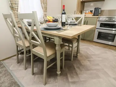 a kitchen with a wooden table and chairs at Hedgehog Lodge in Carnforth