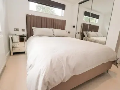 a bedroom with a large white bed and a mirror at Henry Haven in Preston