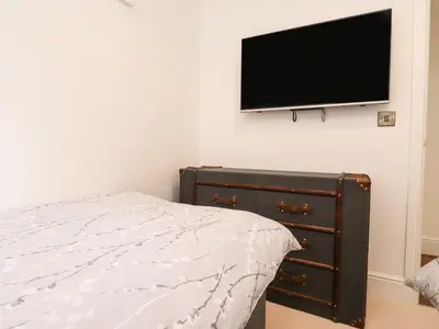 a bedroom with a bed and a flat screen tv on the wall at Henry Haven in Preston