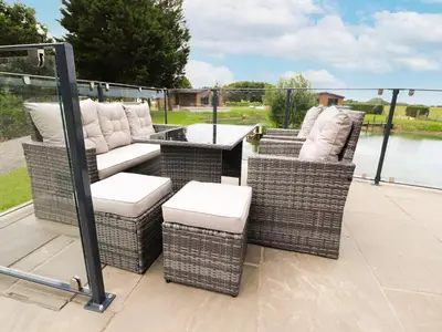 two wicker chairs and a table on a deck at Henry Haven in Preston
