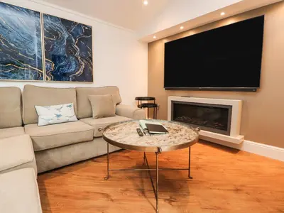 a living room with a couch and a flat screen tv at Henry Haven in Preston