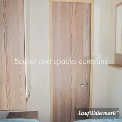 a bedroom with a wooden door and a bed at Blackpool caravans Marton mere in Blackpool