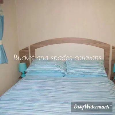 a bedroom with a bed with blue and white stripes at Blackpool caravans Marton mere in Blackpool