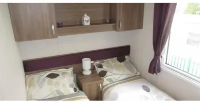 a small bedroom with a bed and a window at Blackpool caravans Marton mere in Blackpool