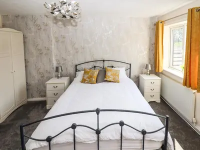 a bedroom with a large bed and two night stands at 8 Heatons Bridge Road in Ormskirk