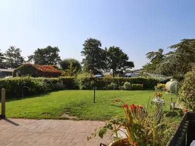 a garden with a lawn with flowers and plants at 8 Heatons Bridge Road in Ormskirk