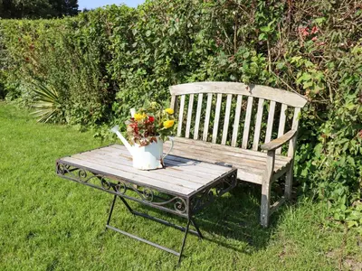 a wooden bench with a vase of flowers on it at 8 Heatons Bridge Road in Ormskirk
